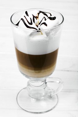 Latte, cappuccino hatmi ışık arka plan ile. Çikolatalı topping