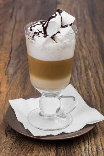 Groot glas met latte en marshmallow op houten tafel — Stockfoto