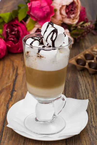 Groot glas met latte en marshmallow op houten tafel — Stockfoto