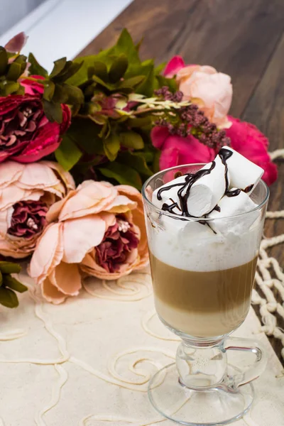 Groot glas met latte en marshmallow op houten tafel — Stockfoto