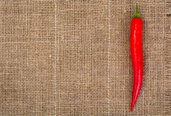 Pod červenou chilli na pozadí tkaniny — Stock fotografie