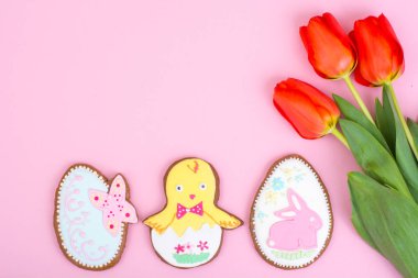 Paskalya hediyeler, tatlı gingerbreads, pastel arka plan üzerinde çiçekler