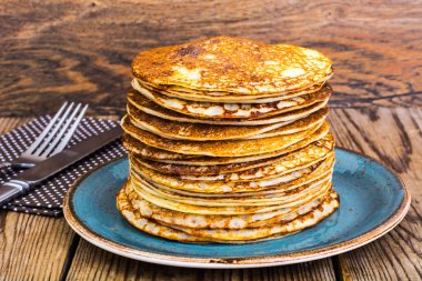 Yüksek ahşap masa üzerinde sıcak krep yığını