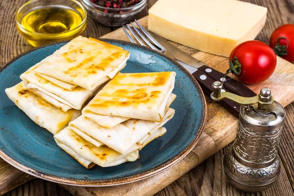 Конверты тонкого армянского хлеба лаваш жареный с хрустящей корочкой. Наполнение сыром, помидорами и зеленью для горячего завтрака — стоковое фото