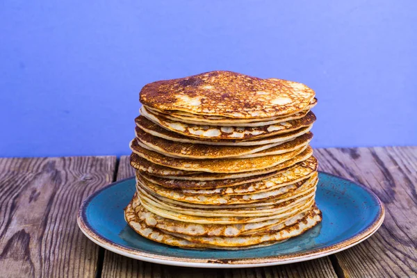 Stack of hot delicious pancakes on bright violet background — Stock Photo, Image