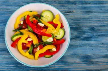 Mavi ahşap zemin üzerine yaz vejetaryen taze sebze salatası