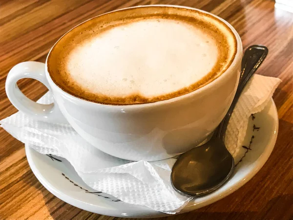 Tasse mit Cappuccino auf Holztisch — Stockfoto