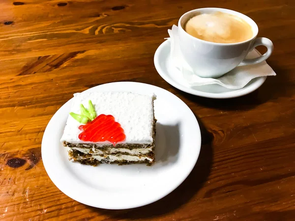 Piece of carrot cake and cappuccino on wooden table