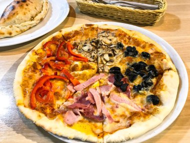 Ahşap masa üzerinde farklı dolguları ile pizza