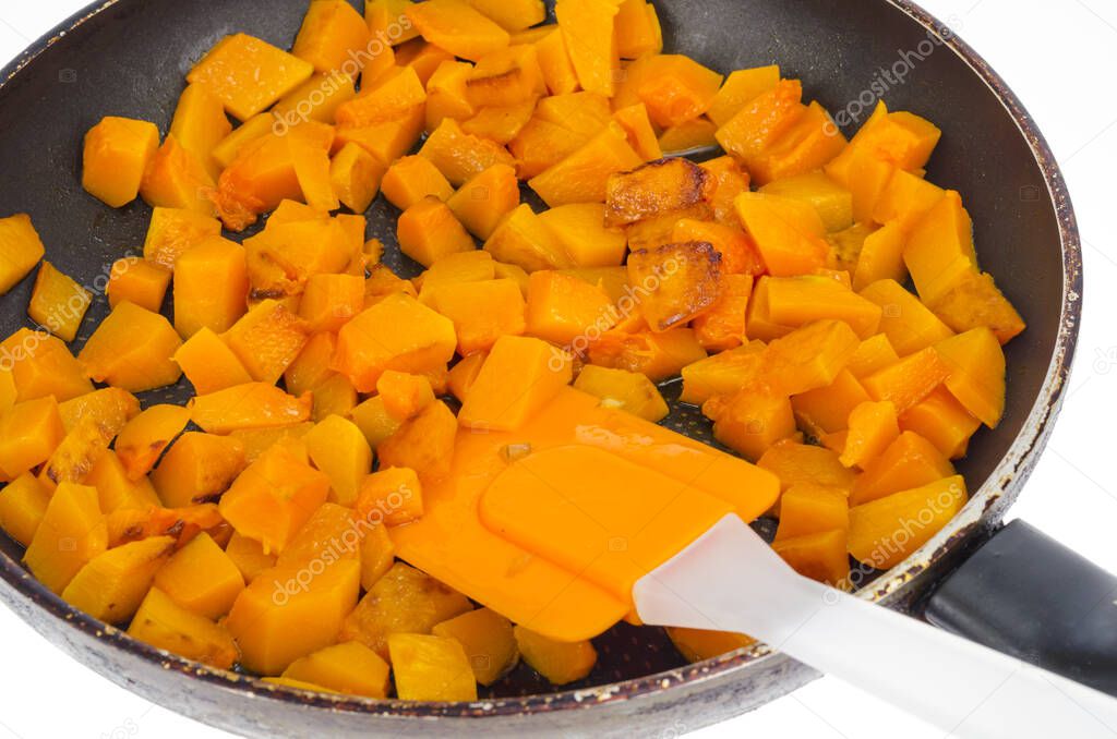 Fried slices of orange nutmeg pumpkin in pan. Studio Photo