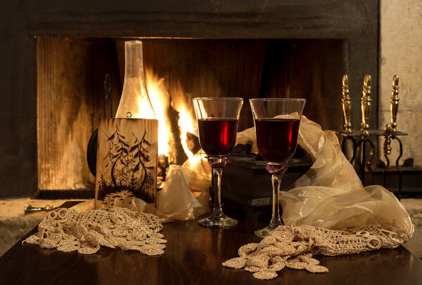 Two glasses of wine of the fireplace