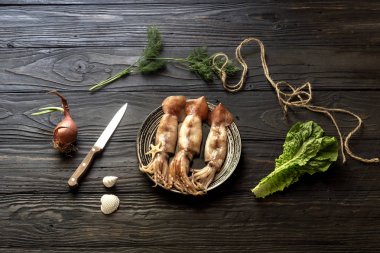 Ahşap bir masada çiğ mürekkep balıkları