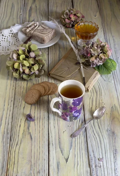 Травяной чай и кондитерские изделия на деревянном столе — стоковое фото