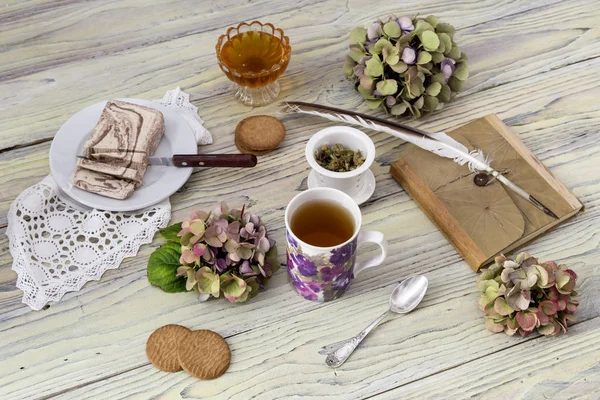 Травяной чай и кондитерские изделия на деревянном столе — стоковое фото