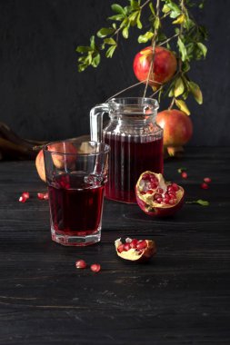 Nar ve nar suyu karanlık bir arka plan üzerinde