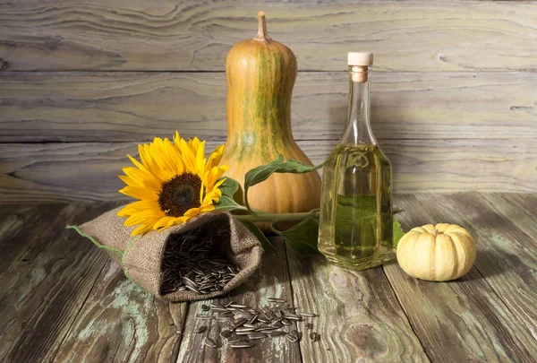 Zonnebloempitten en zonnebloem olie op een houten achtergrond — Stockfoto