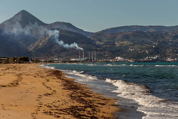 Environmental problem of pollution of environment and air in large cities. Factory for the production of electricity near the sea on the beach (Greece, island Crete)