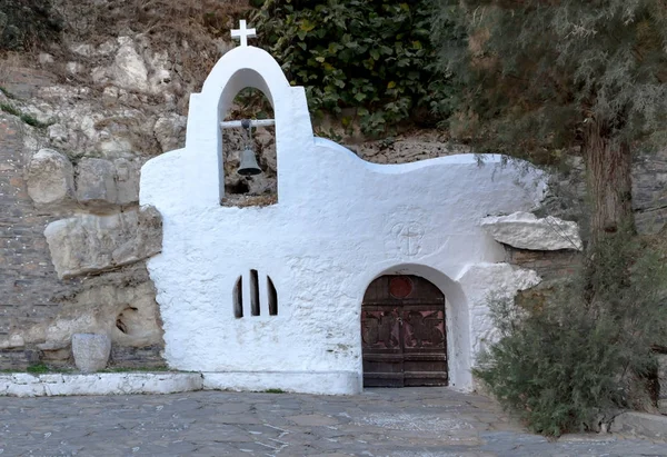 Religion. Ancient, small, Christian, Orthodox, white church with an old door, located in a cave.