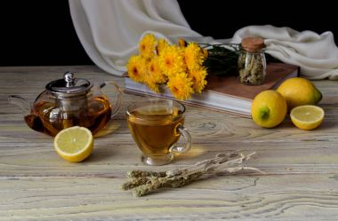Bir bitki ile Faydalı bitkisel çay (Sideritis scardica) veya ahşap bir masada limon ve ahşap bir masa üzerinde sarı krizantem ile Yunan dağ çayı yakın çekim