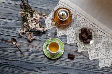 Rustik natürmort. Yararlı, sıcak bitkisel çay, şeker ve badem çiçekli dallar üzerinde ahşap masa yakın çekim