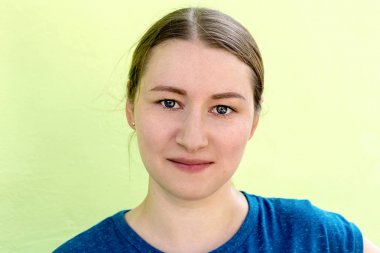 Bir genç, güzel, portresi kız yakın çekim açık yeşil arka plan üzerinde gülümseyen