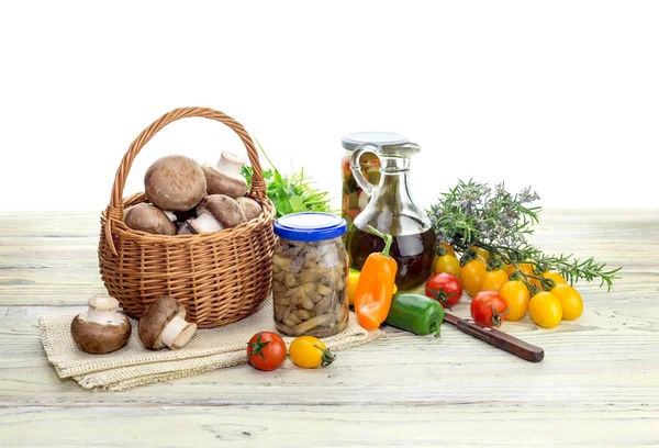 健康饮食 腌制的蔬菜和蘑菇在罐子和原始的樱桃蕃茄 欧芹和蘑菇在一个篮子在一张木桌关闭 — 图库照片