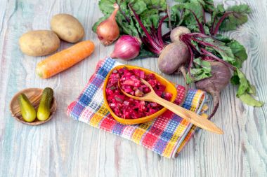 Sağlıklı beslenme. Pancar salatası. Bir ahşap masa yakın çekim bir kase zeytinyağı ile küçük parçalara haşlanmış ve Turşu sebze kesme.