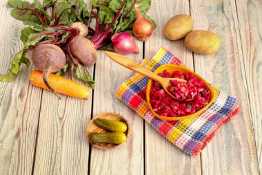 Sağlıklı beslenme. Pancar salatası. Bir ahşap masa yakın çekim bir kase zeytinyağı ile küçük parçalara haşlanmış ve Turşu sebze kesme.