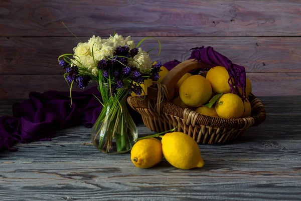 Дикие цветы в вазе и лимонах — стоковое фото