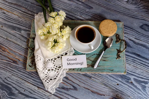 Een kop met koffie in de ochtend en een boeket van bloemen. — Stockfoto