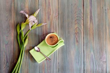 Sabah kahve ve beyaz süsen bir buket ile bir fincan