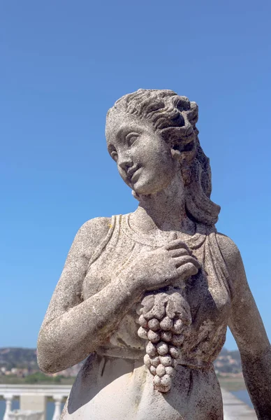 Скульптура дівчини з гроном винограду — стокове фото