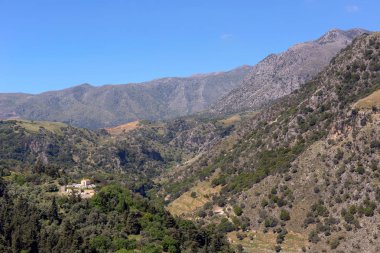 Manzara. Bahar, dağlarda parlak görünüm, bir bahar, güneşli günde (Yunanistan, ada Crete Kilisesi ve köy mezarlığı)