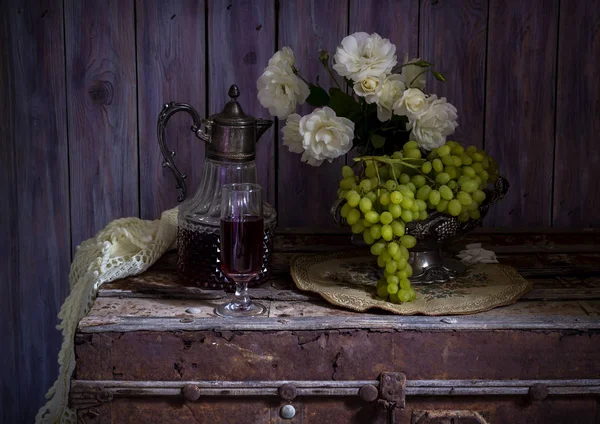 Stilleven met druiven, witte rozen en wijn close-up. — Stockfoto