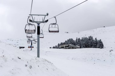Sisli bir günde kayak merkezinde pistin üzerindeki kablo yolu