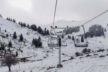 Sisli bir günde kayak merkezinde pistin üzerindeki kablo yolu