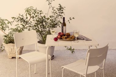 Table with peaches, bakery products and wine on the patio close-