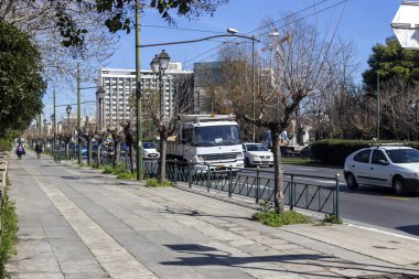 02 / 26 / 220. Atina şehri, Yunanistan. Vasileos Constantinou Bulvarı 'nın modern manzarası, arabalar, motosikletler ve şehir merkezinde güneşli bir kış sabahı insanlar.