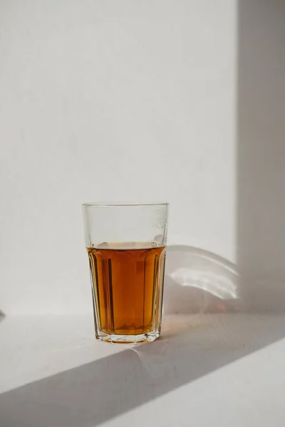 Egy Átlátszó Pohár Fekete Tea Áll Napon Egy Ablakpárkányon — Stock Fotó