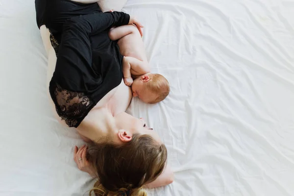 Jovem Mãe Bonita Amamenta Recém Nascido Enquanto Deitado Cama — Fotografia de Stock