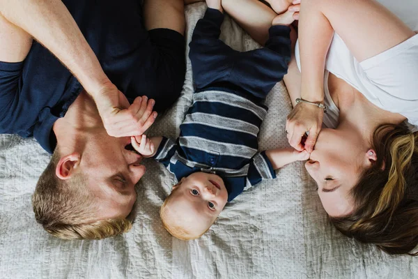 Jovens Pais Deitam Cama Beijam Mãos Bebê — Fotografia de Stock