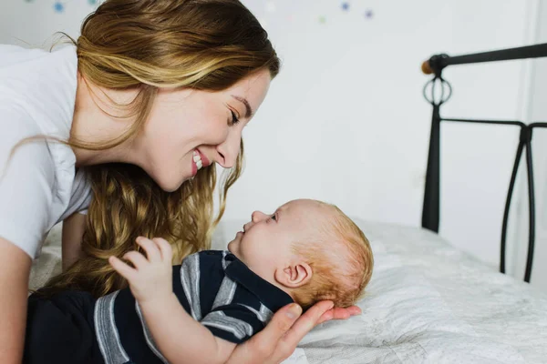 Uma Jovem Mãe Segura Bebê Seus Braços Olha Para Ele — Fotografia de Stock