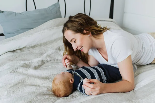 Uma Jovem Mãe Deita Com Bebê Cama Sorri Para Ele — Fotografia de Stock