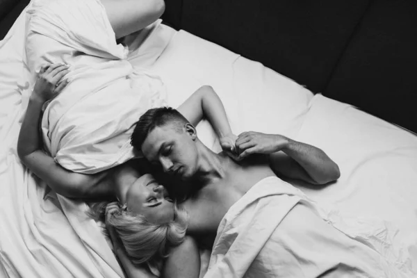 年轻男女依偎在床上 一男一女躺在派对上的黑白照片 — 图库照片