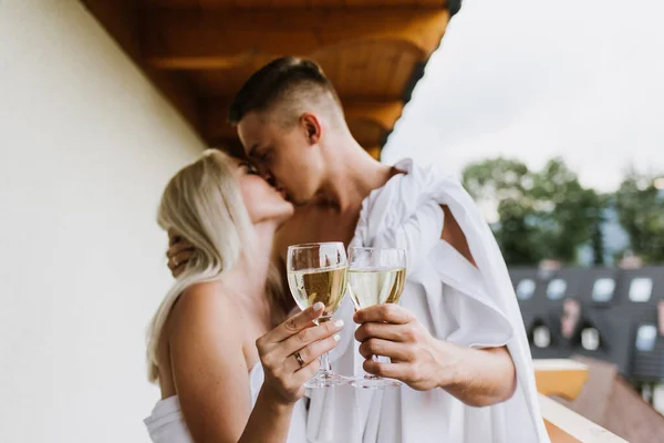 Giovane Uomo Donna Lenzuola Bacio Sul Balcone Tenere Bicchieri Champagne — Foto Stock