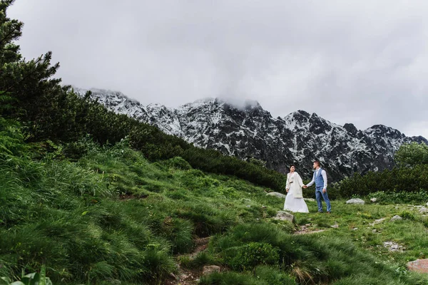 美丽的新娘和新郎在山上散步 新郎新娘在山里 — 图库照片