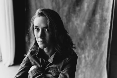 Stüdyoda kot ceketli güzel çıplak kadın. Çıplak bir kadının siyah beyaz fotoğrafı..