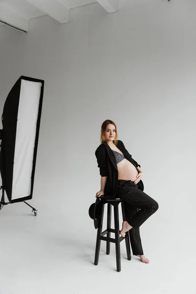 Stüdyoda Siyah Takım Elbiseli Beyaz Arka Planda Hamile Bir Kadın Telifsiz Stok Imajlar
