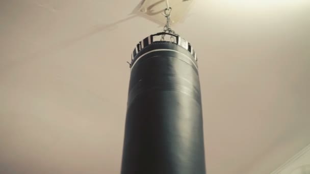Черная боксерская груша висит в боксерской комнате — стоковое видео