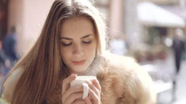 Akıllı kız portresi yakından buğulaması bir fincan kahve içer. 4k